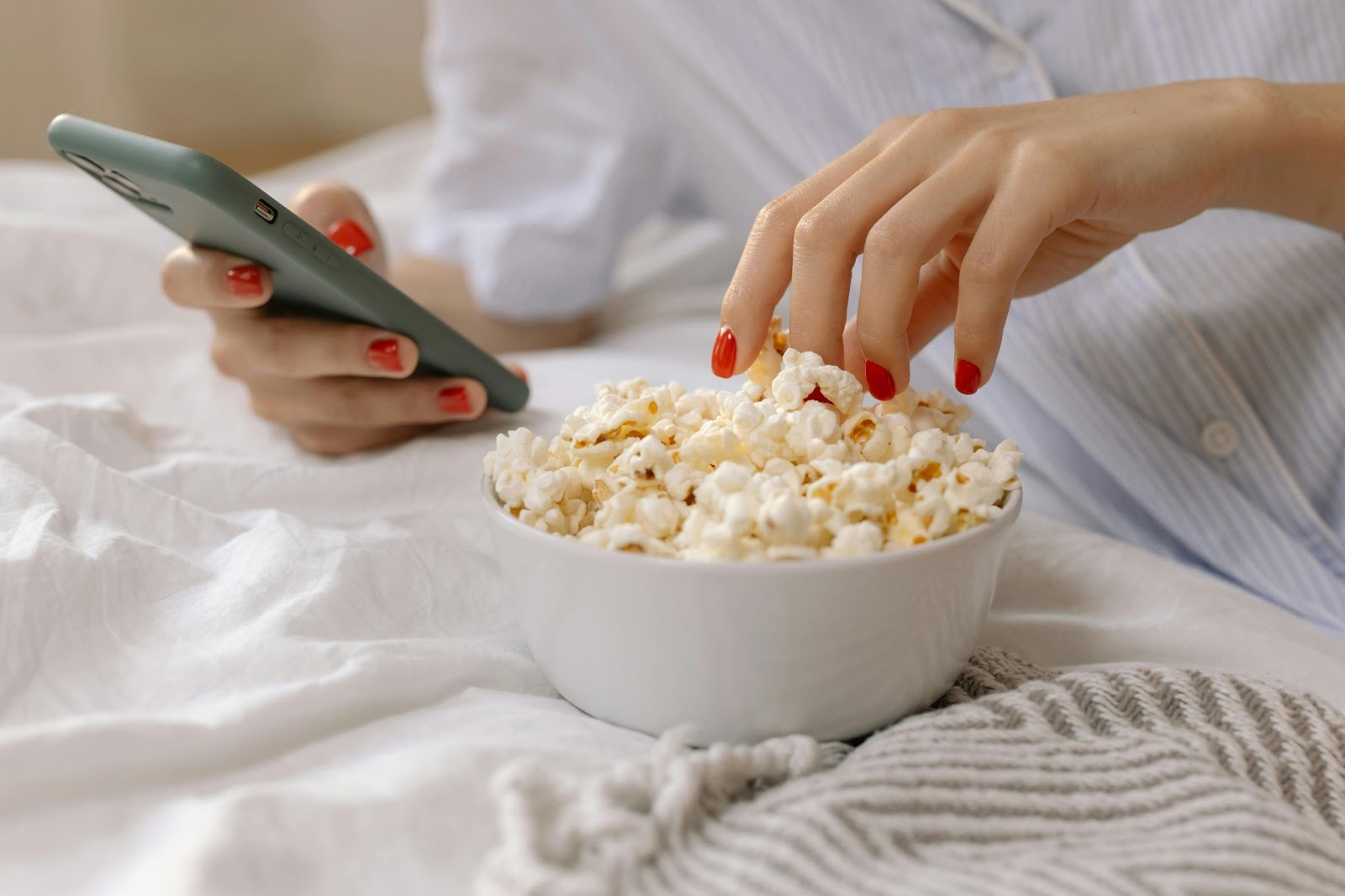 Person Eating Popcorn and on the Phone